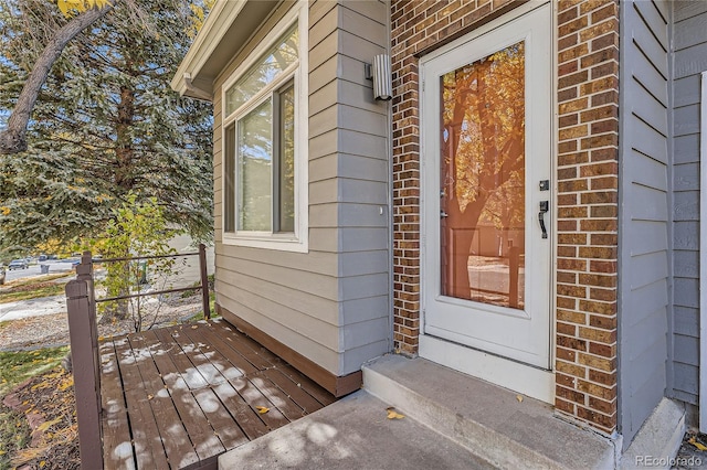 view of exterior entry with a wooden deck