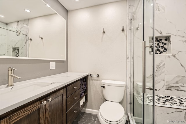 bathroom with a shower with door, vanity, and toilet