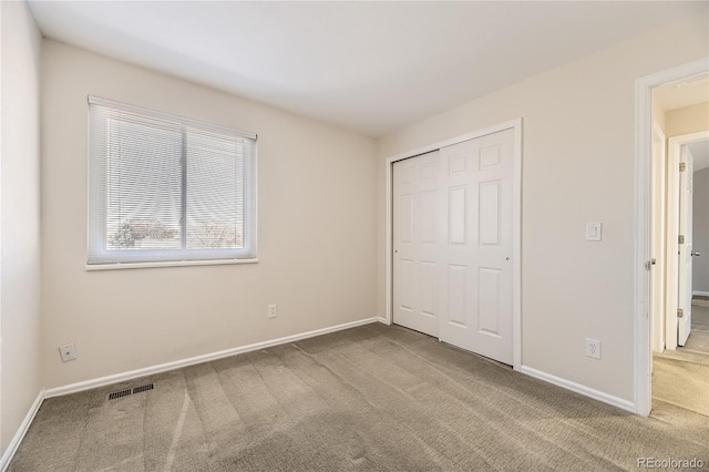 unfurnished bedroom with a closet and carpet floors