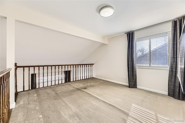 additional living space with lofted ceiling with beams and carpet