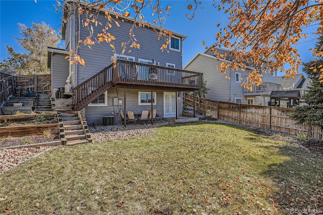 back of house featuring a wooden deck and a lawn