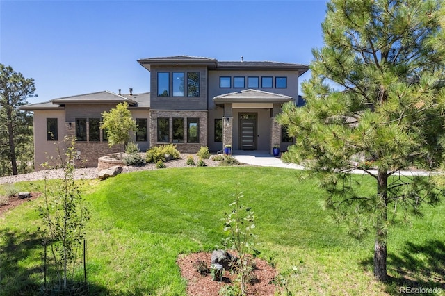 rear view of property with a yard and stone siding