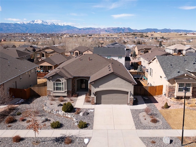 view of front of home with a garage, fence, concrete driveway, a residential view, and stucco siding