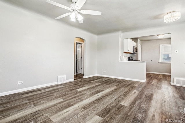 unfurnished living room with dark hardwood / wood-style floors and ceiling fan