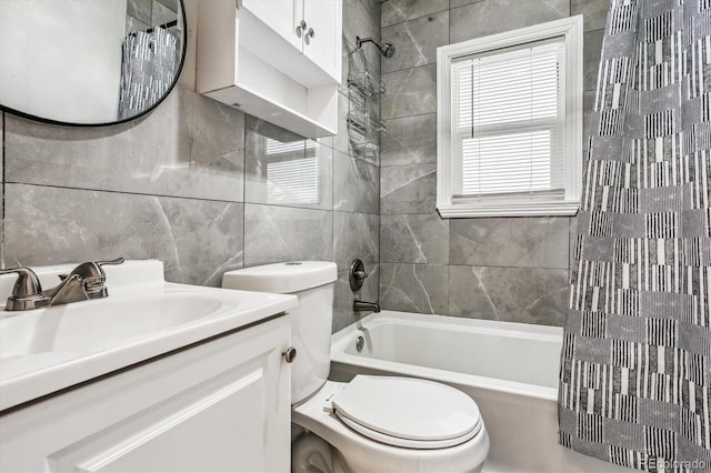 full bathroom with vanity, tile walls, shower / bathtub combination with curtain, and toilet