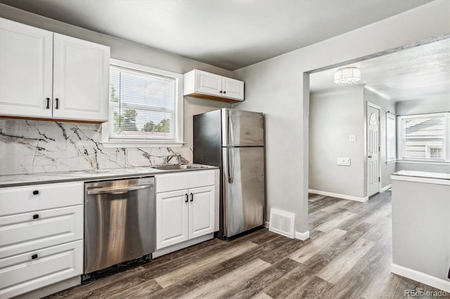 kitchen featuring appliances with stainless steel finishes, tasteful backsplash, sink, dark hardwood / wood-style floors, and white cabinetry