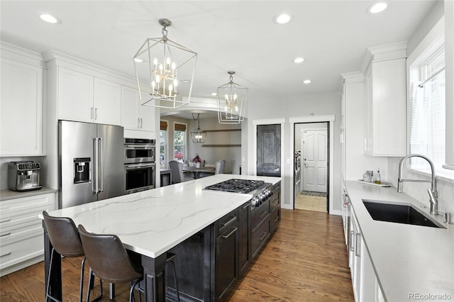 10601 Chadsworth Ln, Highlands Ranch, CO 80126 - kitchen featuring stainless steel appliances, a center island, white cabinets, a chandelier, and recessed lighting