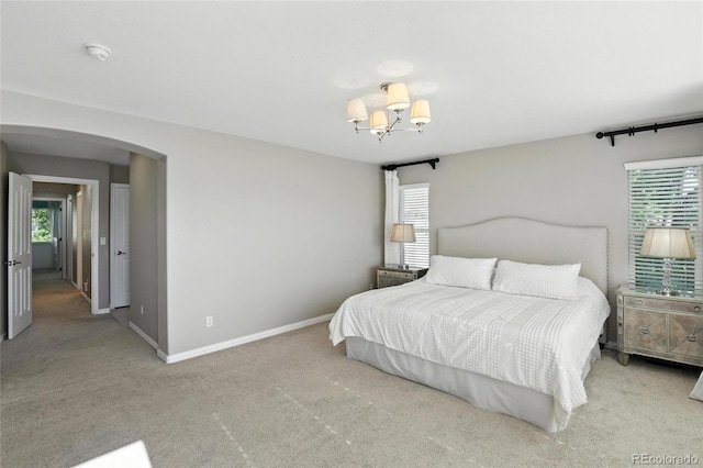 10601 Chadsworth Ln, Highlands Ranch, CO 80126 - carpeted bedroom featuring arched walkways, multiple windows, and a chandelier