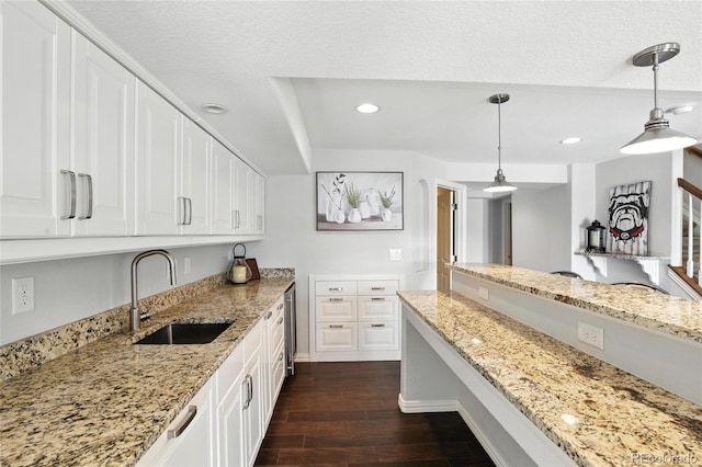 10601 Chadsworth Ln, Highlands Ranch, CO 80126 - kitchen with dark wood-style flooring, white cabinetry, light stone countertops, and recessed lighting