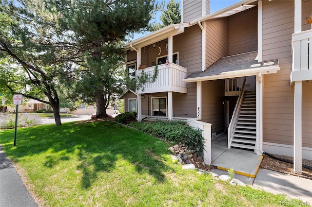 view of front of house with a balcony and a front yard