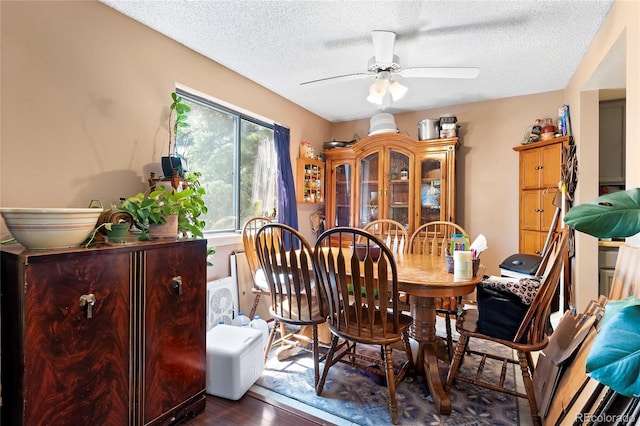 dining area with ceiling fan, a textured ceiling, and hardwood / wood-style flooring