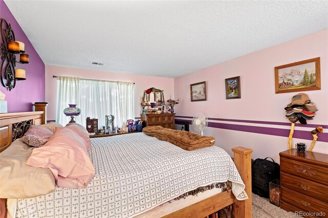 bedroom featuring carpet flooring and a textured ceiling