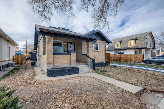 bungalow-style house with fence and brick siding