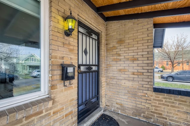 entrance to property featuring brick siding