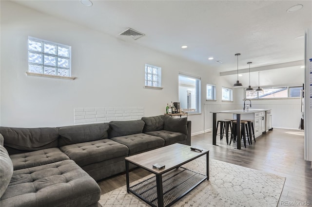 living area with visible vents, recessed lighting, baseboards, and wood finished floors