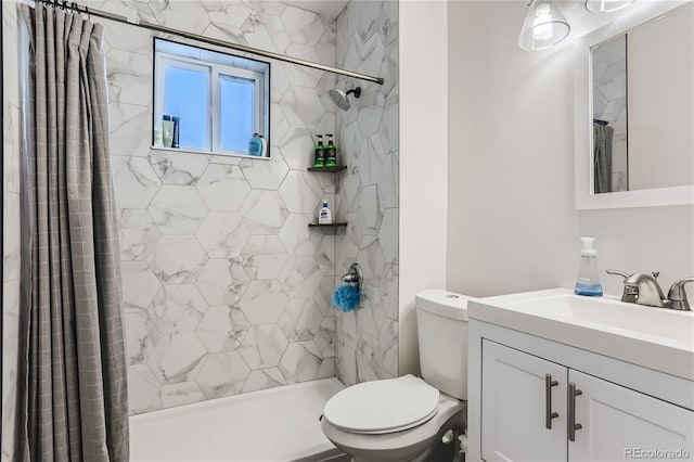 bathroom with vanity, toilet, and a tile shower