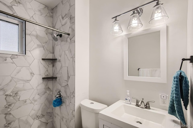 full bath featuring tiled shower, toilet, and vanity