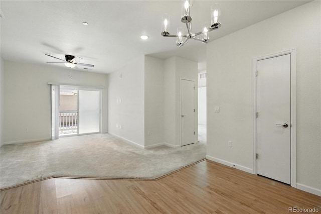 1881 S Dunkirk St Unit 106, Aurora, CO 80017 - carpeted empty room featuring baseboards, wood finished floors, and ceiling fan with notable chandelier