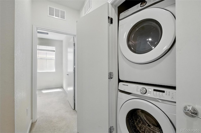1881 S Dunkirk St Unit 106, Aurora, CO 80017 - laundry area featuring stacked washer and dryer, laundry area, visible vents, and carpet