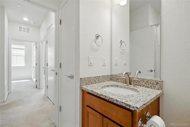 1881 S Dunkirk St Unit 106, Aurora, CO 80017 - bathroom with vanity, a textured wall, and visible vents