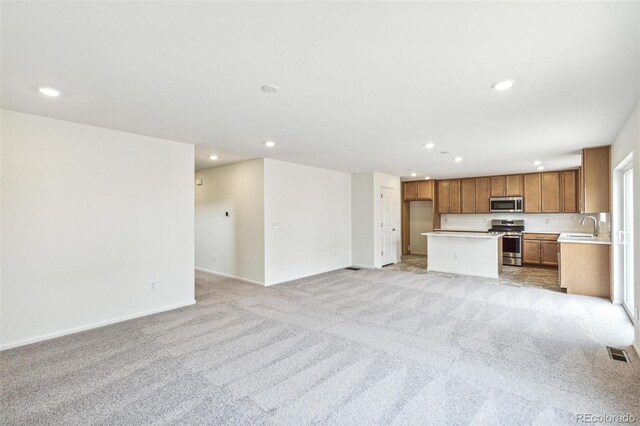 20724 E 57th Ave, Aurora, CO 80019 - unfurnished living room featuring a sink, light carpet, recessed lighting, and baseboards