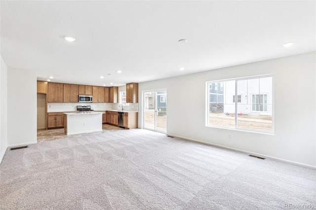 20724 E 57th Ave, Aurora, CO 80019 - kitchen with appliances with stainless steel finishes, open floor plan, brown cabinetry, light countertops, and recessed lighting