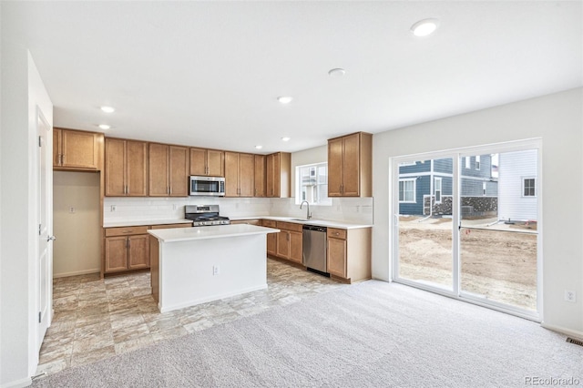 20724 E 57th Ave, Aurora, CO 80019 - kitchen featuring appliances with stainless steel finishes, a sink, brown cabinets, light countertops, and backsplash
