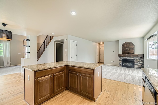 13018 Niagara Way, Thornton, CO 80602 - kitchen featuring light wood-style flooring, dishwasher, a stone fireplace, light stone countertops, and recessed lighting
