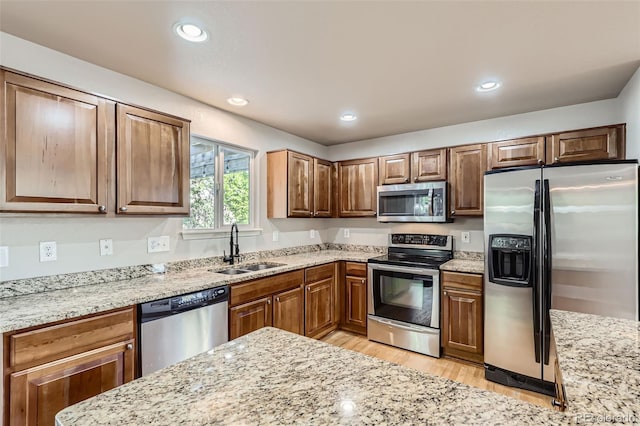 13018 Niagara Way, Thornton, CO 80602 - kitchen featuring stainless steel appliances, light wood-type flooring, light stone countertops, recessed lighting, and brown cabinets
