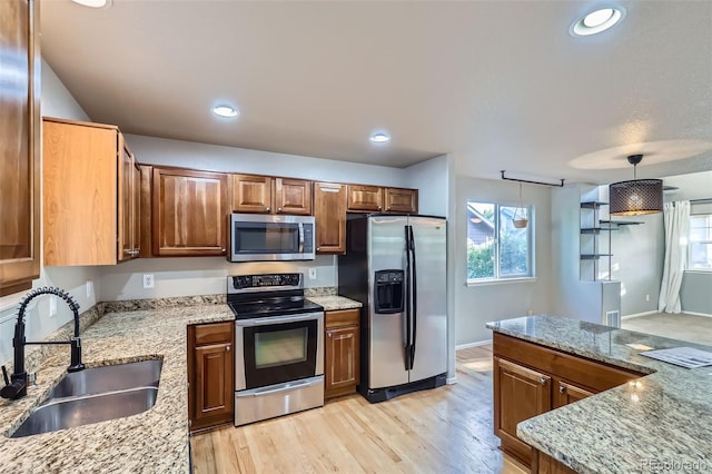 13018 Niagara Way, Thornton, CO 80602 - kitchen with stainless steel appliances, light stone countertops, light wood finished floors, recessed lighting, and brown cabinetry