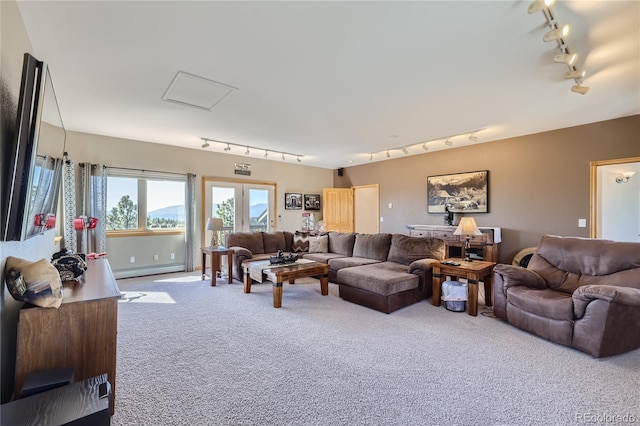 carpeted living room featuring a baseboard heating unit and track lighting