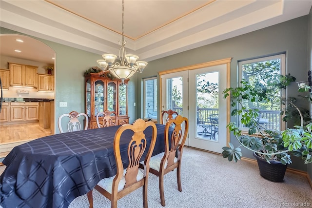 dining area featuring a tray ceiling and a notable chandelier