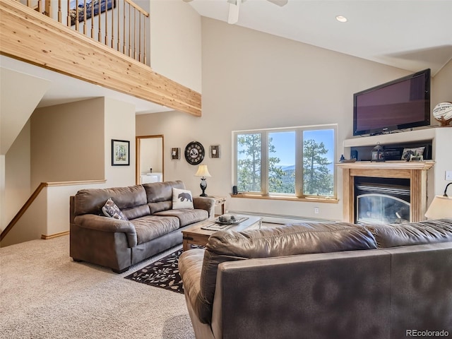 living room with ceiling fan, a baseboard radiator, a high ceiling, and carpet flooring