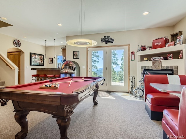 playroom featuring a tile fireplace and light carpet