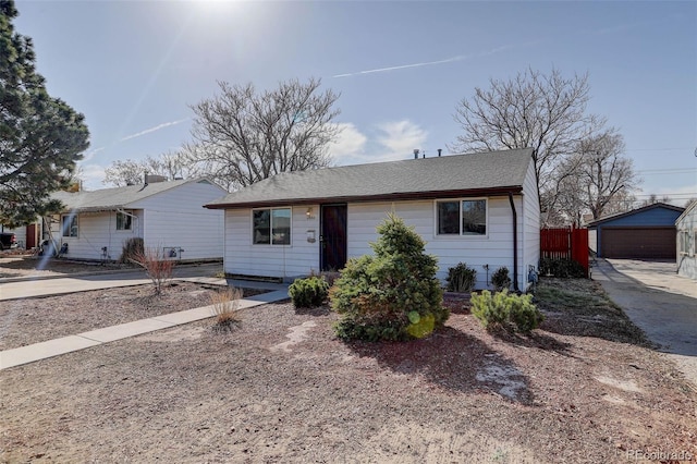 ranch-style house featuring a garage, an outbuilding, and fence