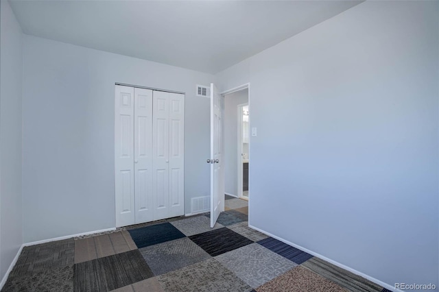 unfurnished bedroom with visible vents, baseboards, carpet, and a closet