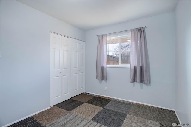 unfurnished bedroom with a closet and baseboards