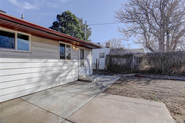 view of side of property with a patio and fence