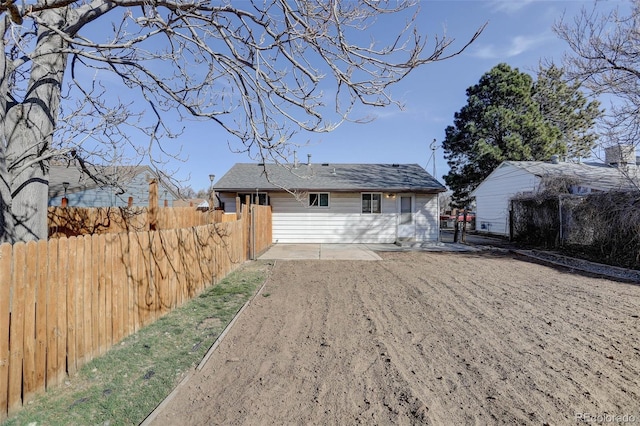 rear view of property featuring a patio and fence