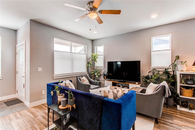 living room with baseboards, light wood-style flooring, and a healthy amount of sunlight