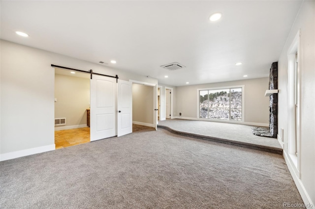 basement featuring a barn door and light carpet