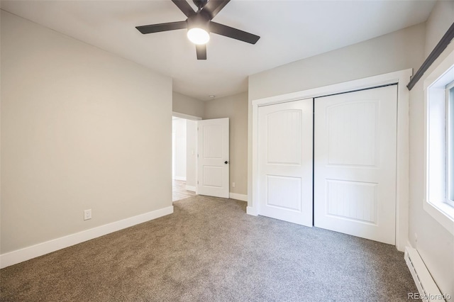 unfurnished bedroom with ceiling fan, carpet flooring, a closet, and a baseboard heating unit