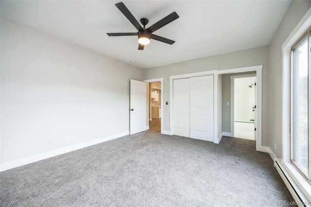 unfurnished bedroom with baseboard heating, ceiling fan, carpet floors, and a closet