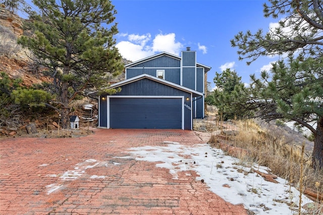 snow covered property with a garage