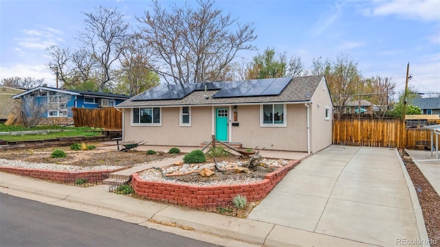 741 Cortez St, Denver, CO 80221 - ranch-style house with fence, a shingled roof, stucco siding, solar panels, and driveway