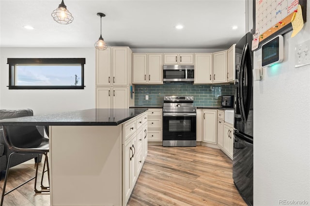 741 Cortez St, Denver, CO 80221 - kitchen featuring light wood-style floors, dark countertops, stainless steel appliances, and cream cabinetry