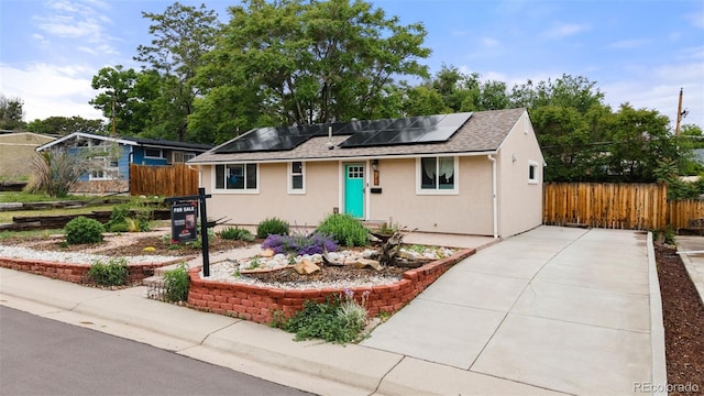741 Cortez St, Denver, CO 80221 - single story home featuring stucco siding, roof mounted solar panels, driveway, and roof with shingles