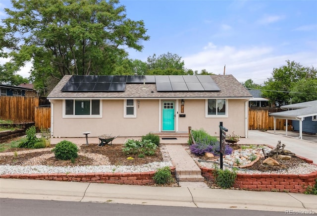741 Cortez St, Denver, CO 80221 - view of front facade with stucco siding, solar panels, a shingled roof, and driveway