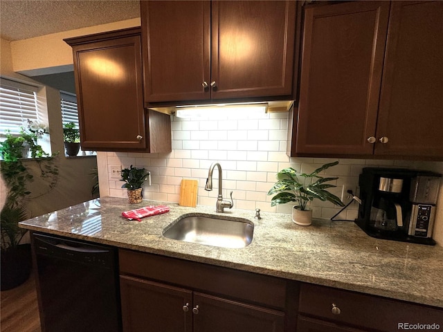 kitchen with light stone counters, dark brown cabinetry, a sink, decorative backsplash, and dishwasher