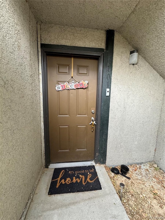 doorway to property featuring stucco siding